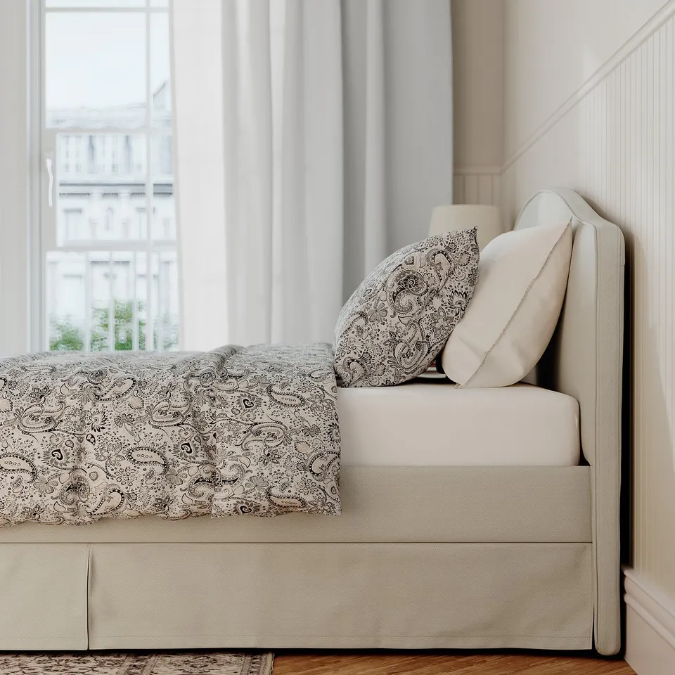 Bed frame with padded headboard, removable cover, and piped edges, ideal for reading or resting.