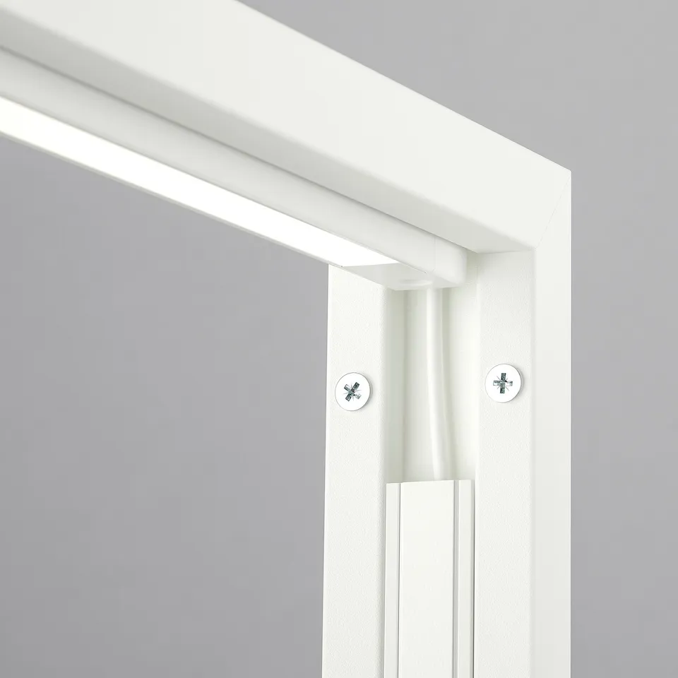 White MITTZON partition frame with two screws visible, set against a light grey wall. High-quality appearance.
