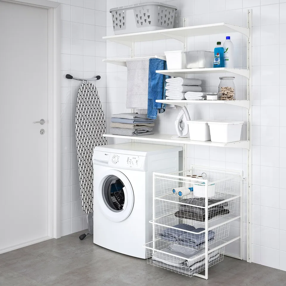 Modern laundry setup with JONAXEL shelves storing towels, detergents, and ironing board.