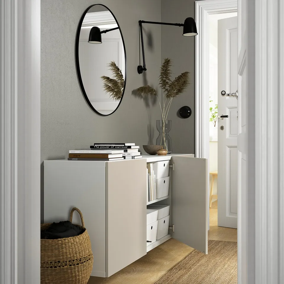 Modern entryway with BESTÅ storage, featuring adjustable shelves, wall-mounted design, and decorative items.