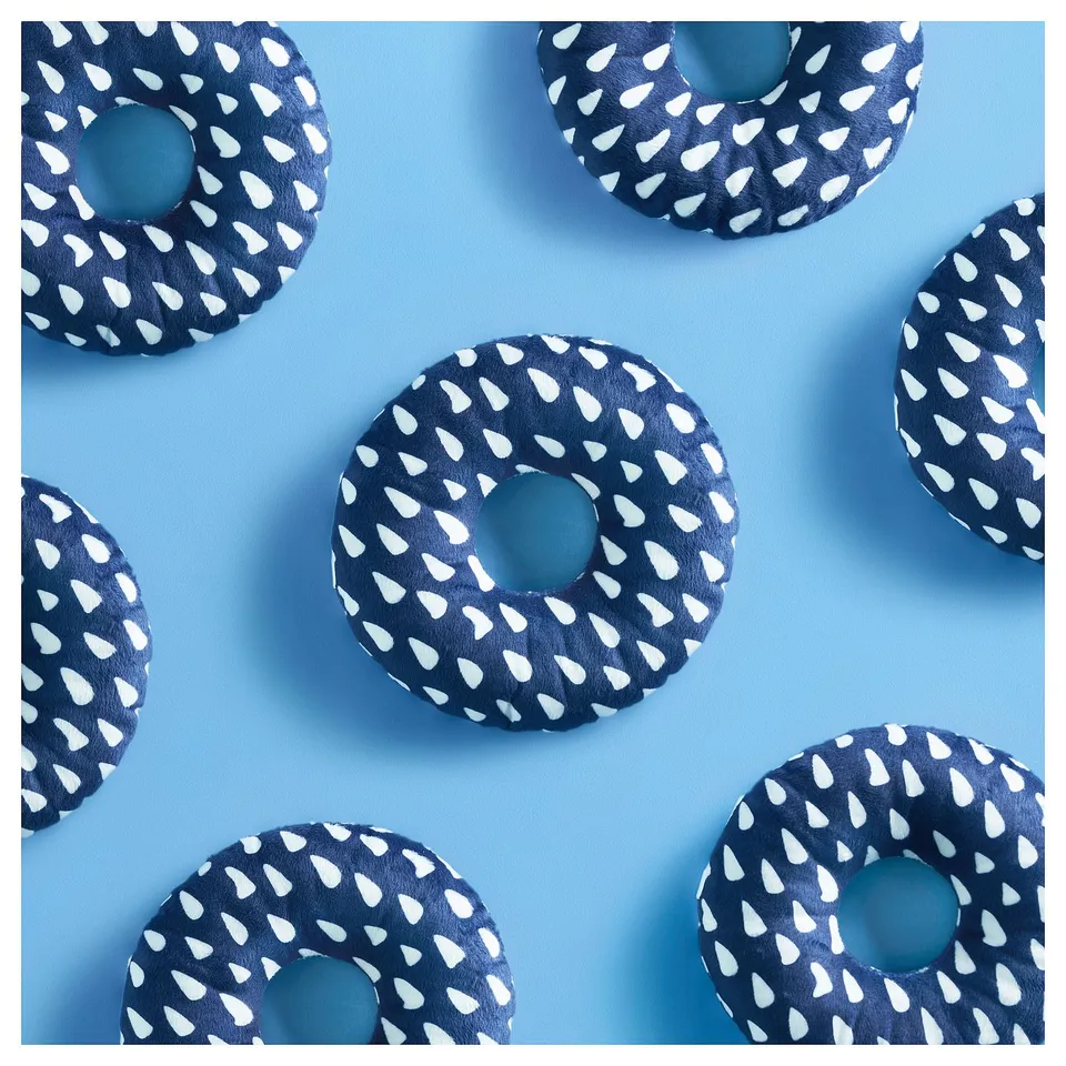Blue dog toys, round with white polka dots, scattered on light blue background.
