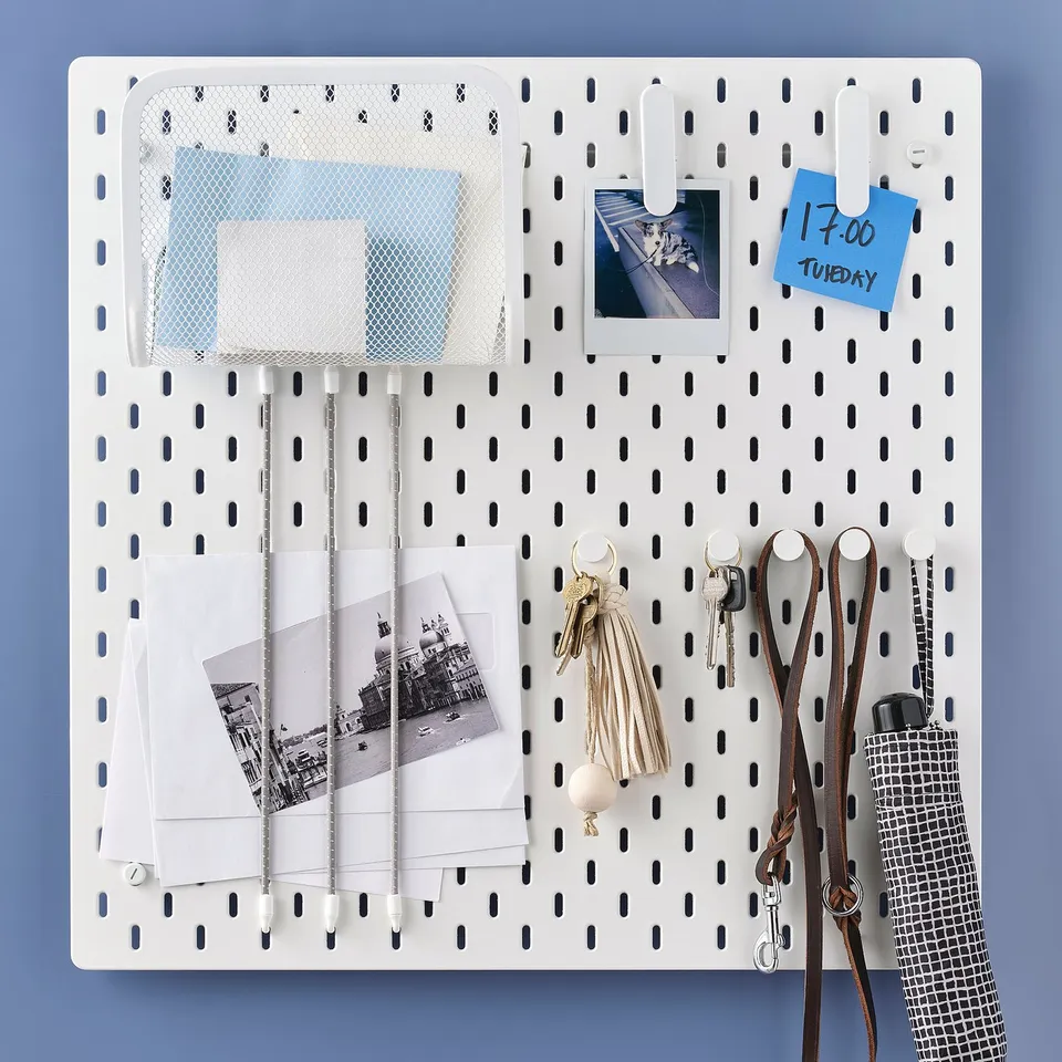SKÅDIS pegboard organiser with hooks, keys, photos, memo, and accessories neatly arranged.