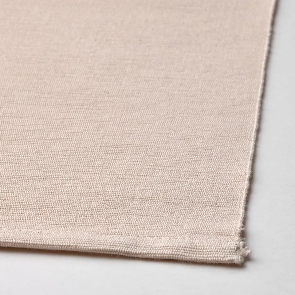 Close-up of woven beige fabric, showcasing textured weave and quality craftsmanship.