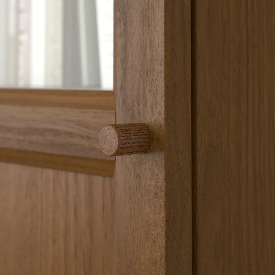 Close-up of wooden door hinge; smooth, polished wood texture visible.