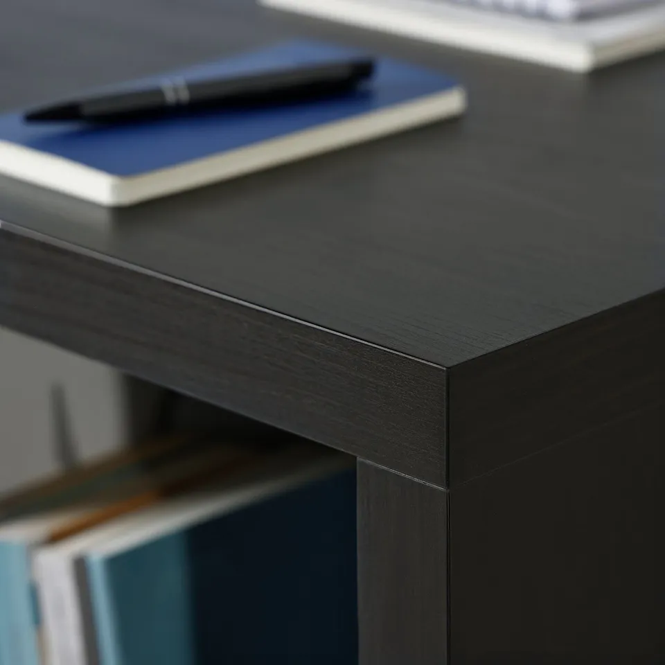 Black KALLAX desk with pen, book, and laptop.