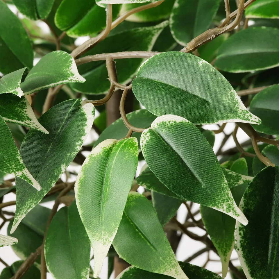 Artificial leaves in varying shades of green, attached to thin stems, closely resembling real plants.