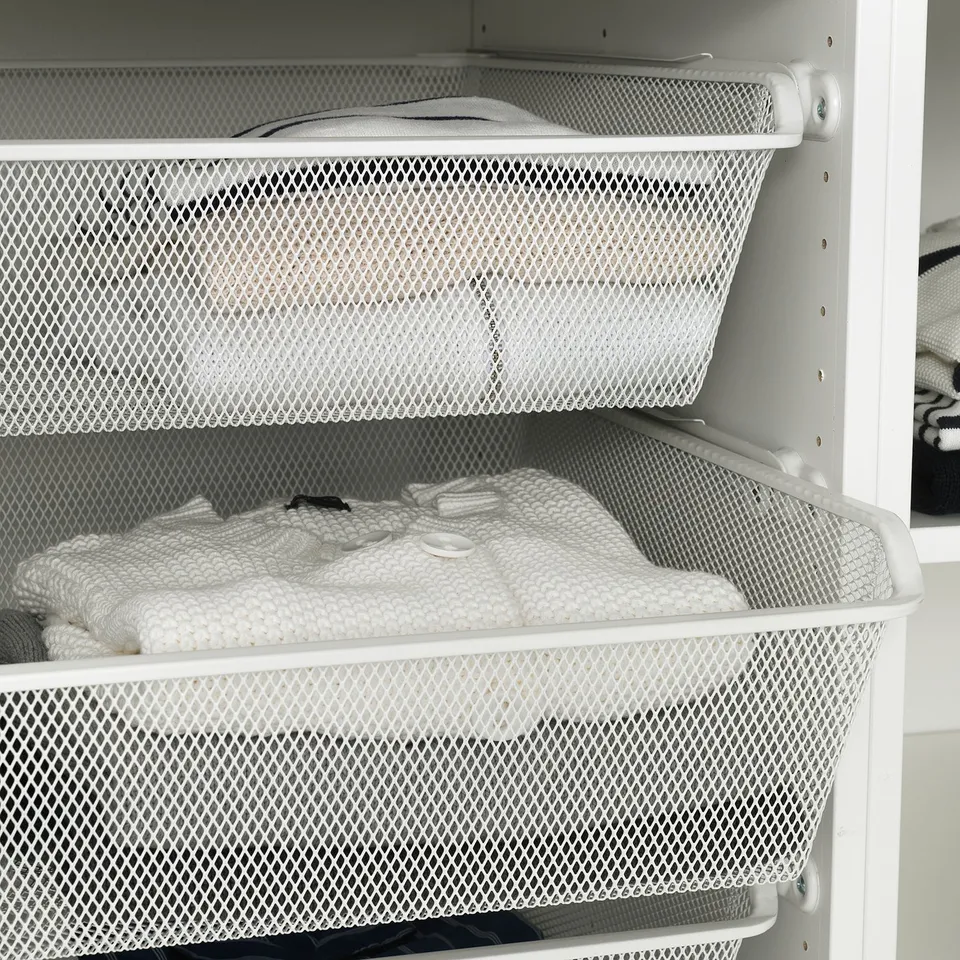 White mesh baskets in PAX wardrobe, storing folded clothes, optimising storage space.