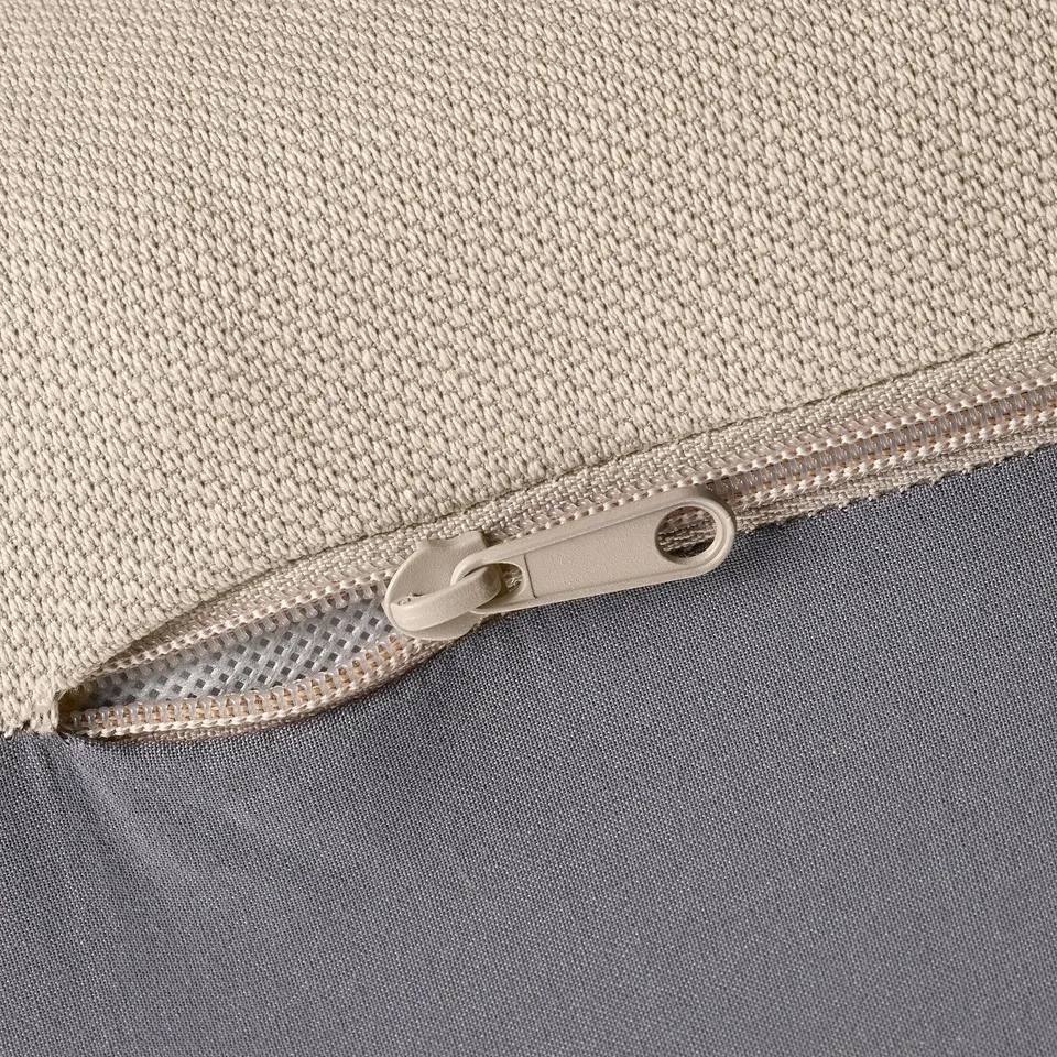 Close-up of zip on durable, textured fabric bag. Zip pulled halfway, showing smooth, quality material.