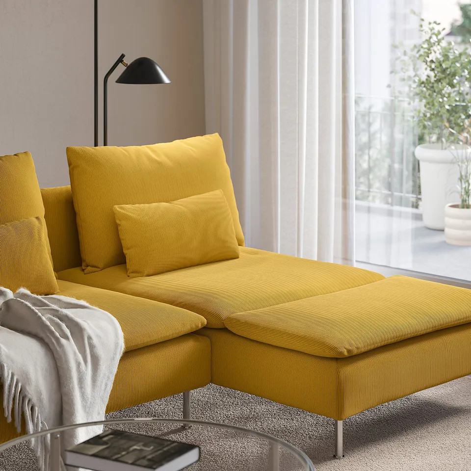 Yellow l-sofa with remote on glass table, cosy family seating.