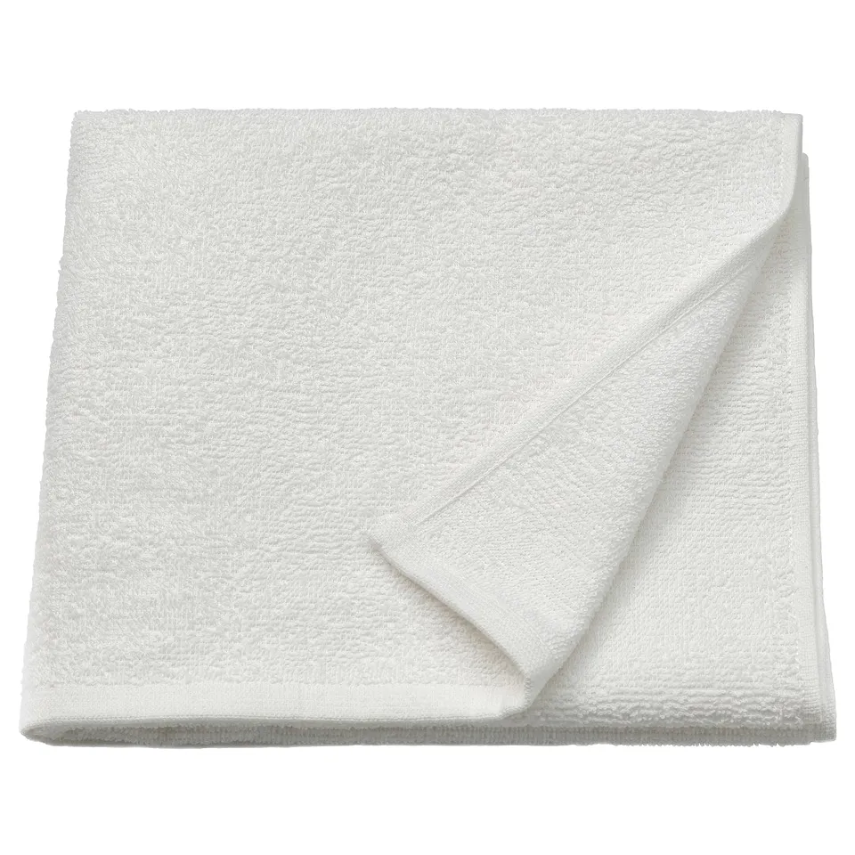 Folded white LUDDVIAL towel of 100% cotton, soft, quick-drying, compact design.
