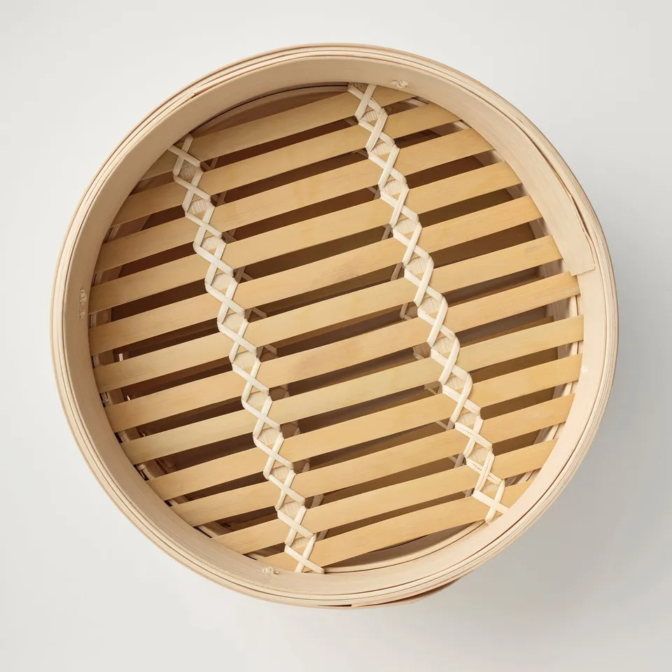 Round bamboo steamer with two-tier design, ideal for cooking and serving various foods, showcasing quality craftsmanship and natural material.