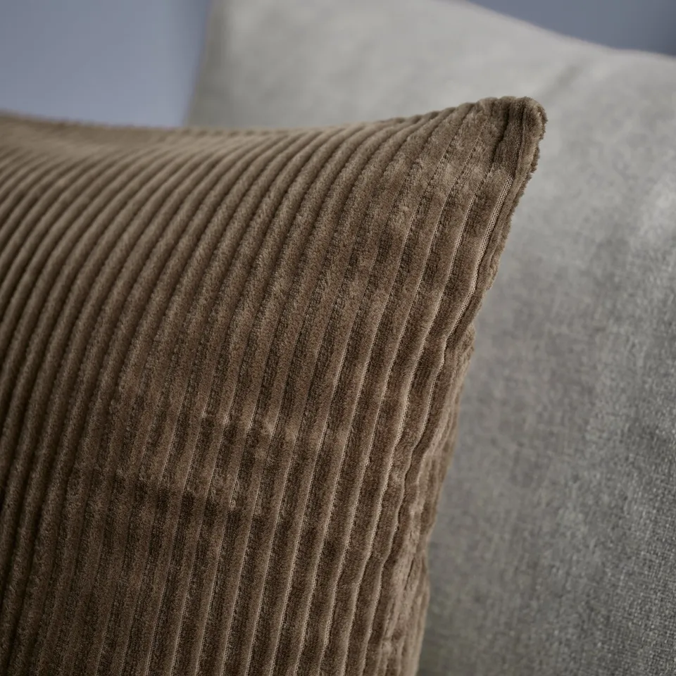Cushion close-up: soft, brown corduroy with subtle stripes, high-quality fabric.