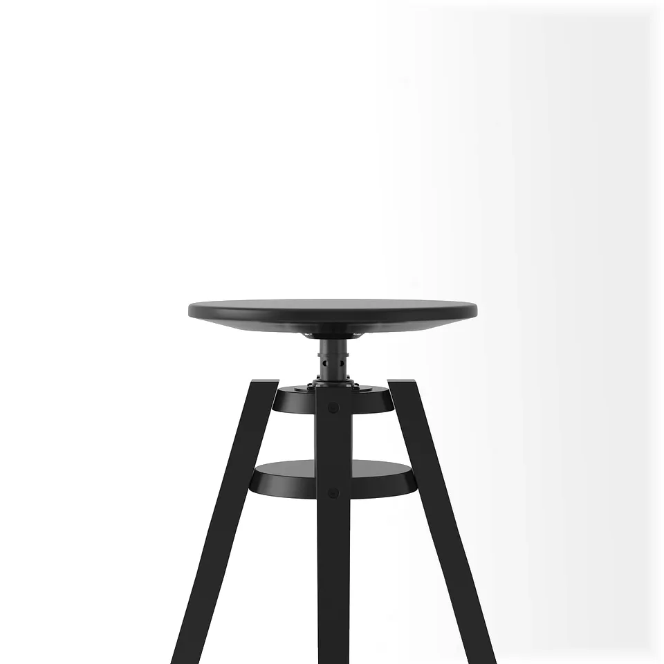 Black adjustable stool with round seat, three sturdy legs, and a footrest, designed for durability and comfort.