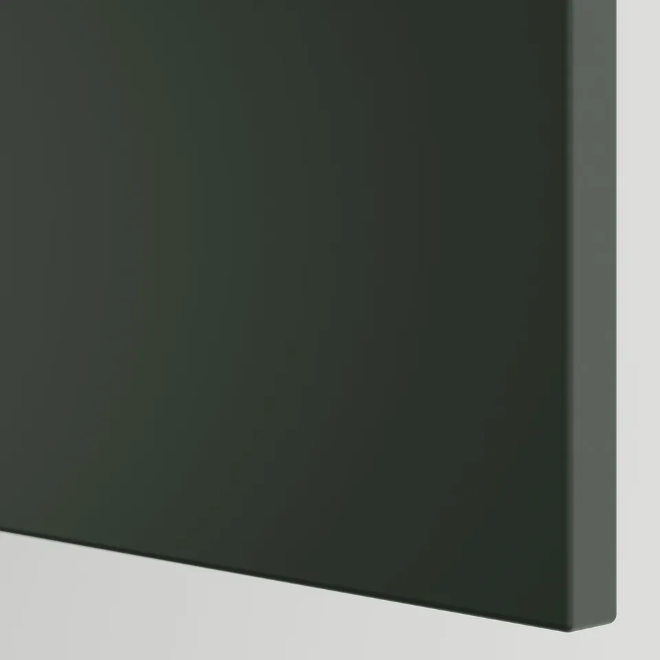 Dark green, modern kitchen cabinet corner. Sleek design, smooth surfaces, high-quality finish.