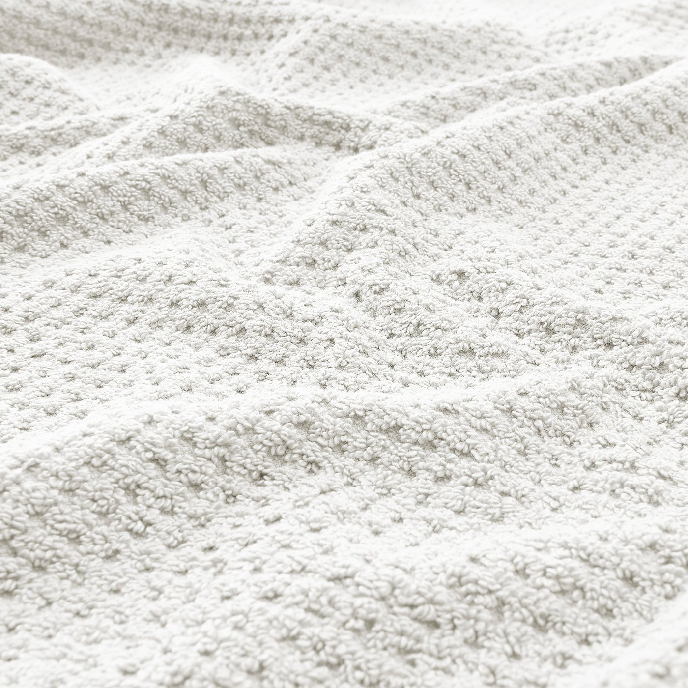 Close-up of soft, beige GULVIAL towel showcasing its thick, fluffy texture and intricate weave.
