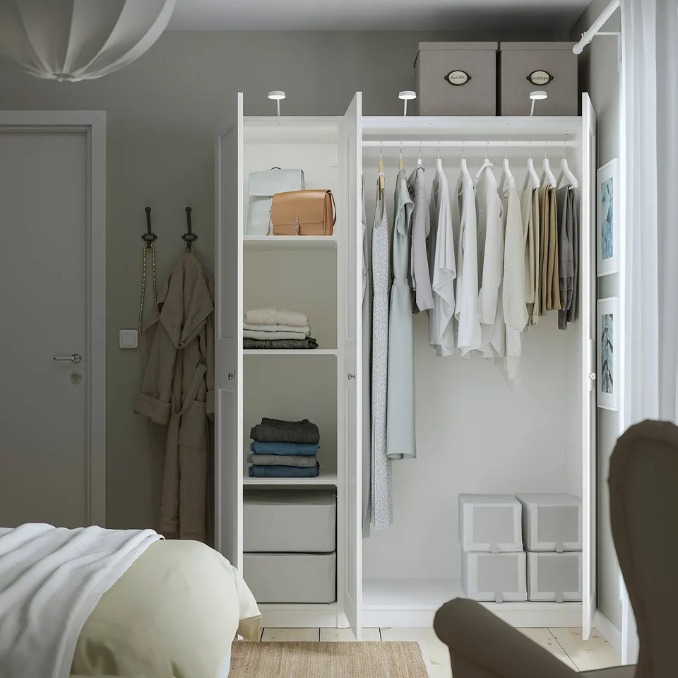 A neatly organised wardrobe with hangers, shelves, and storage boxes, showcasing the PAX systems adaptable and spacious design.