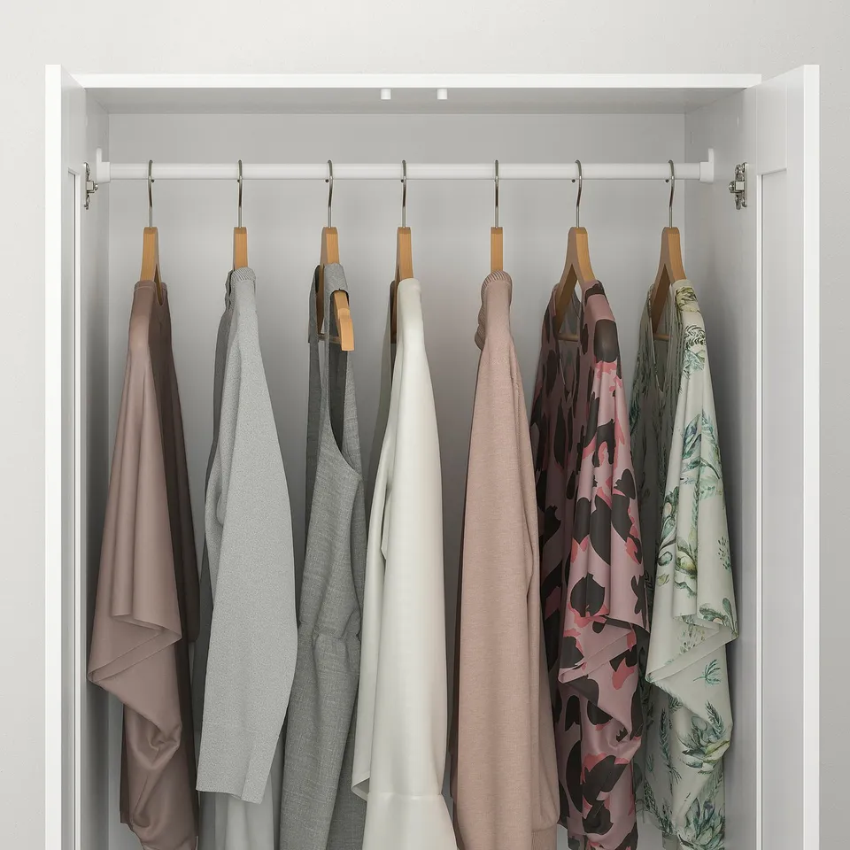 Closet with clothes hangers: six shirts, varied colours, organised neatly.