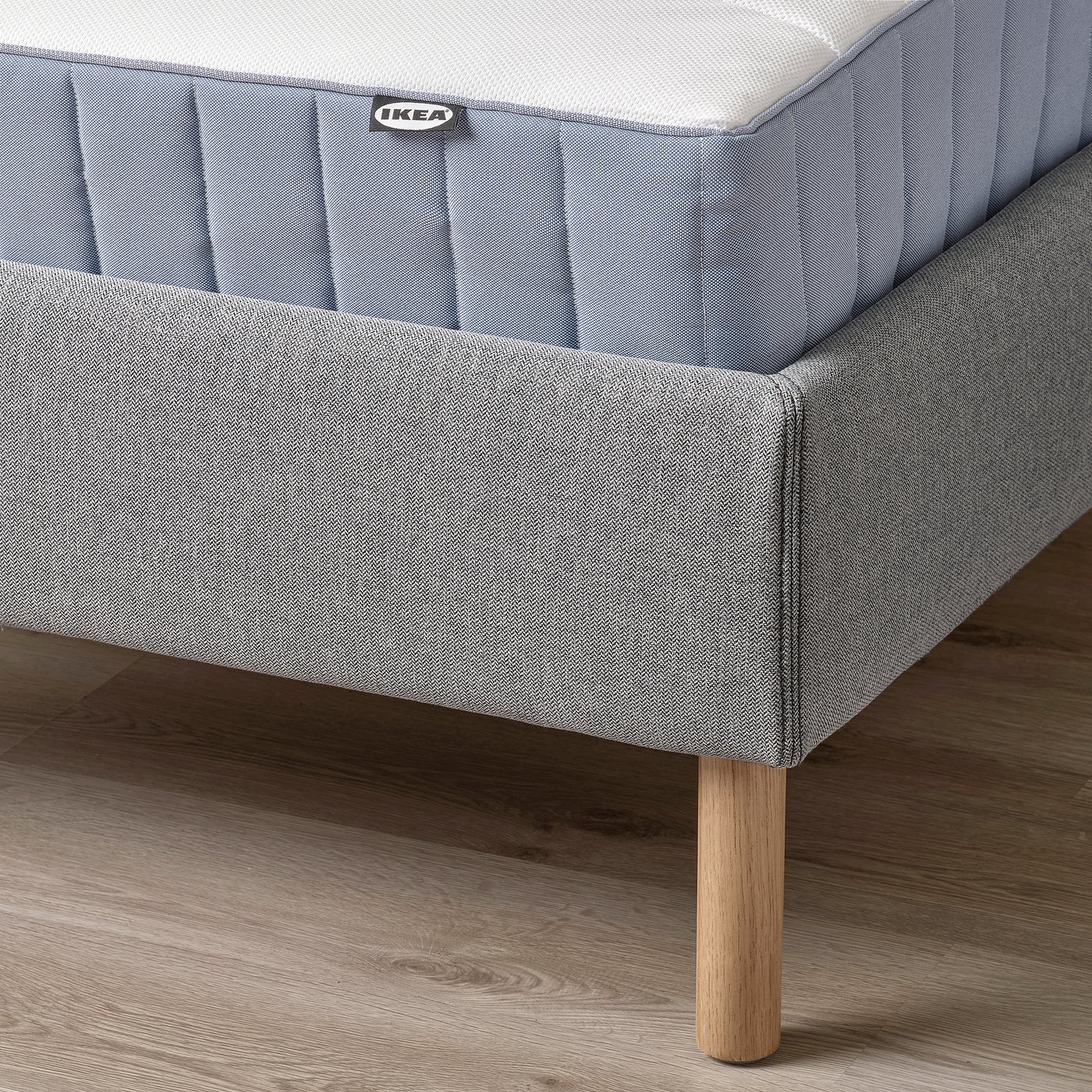 A modern bed frame with a removable, machine-washable fabric cover and a padded headboard for comfort. It wooden legs, promoting a natural look.