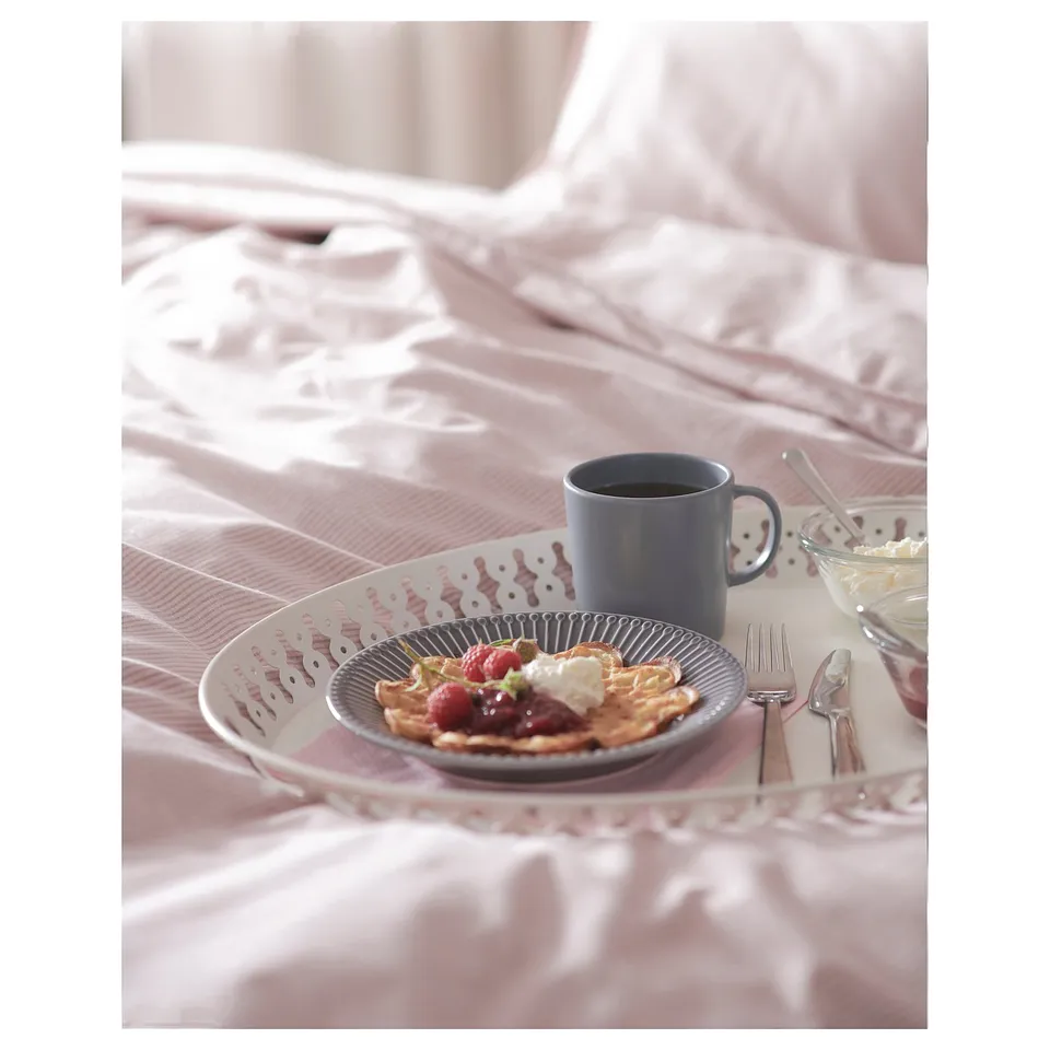 Blue tray with waffles, berries, and blue mug on satin pink bed.