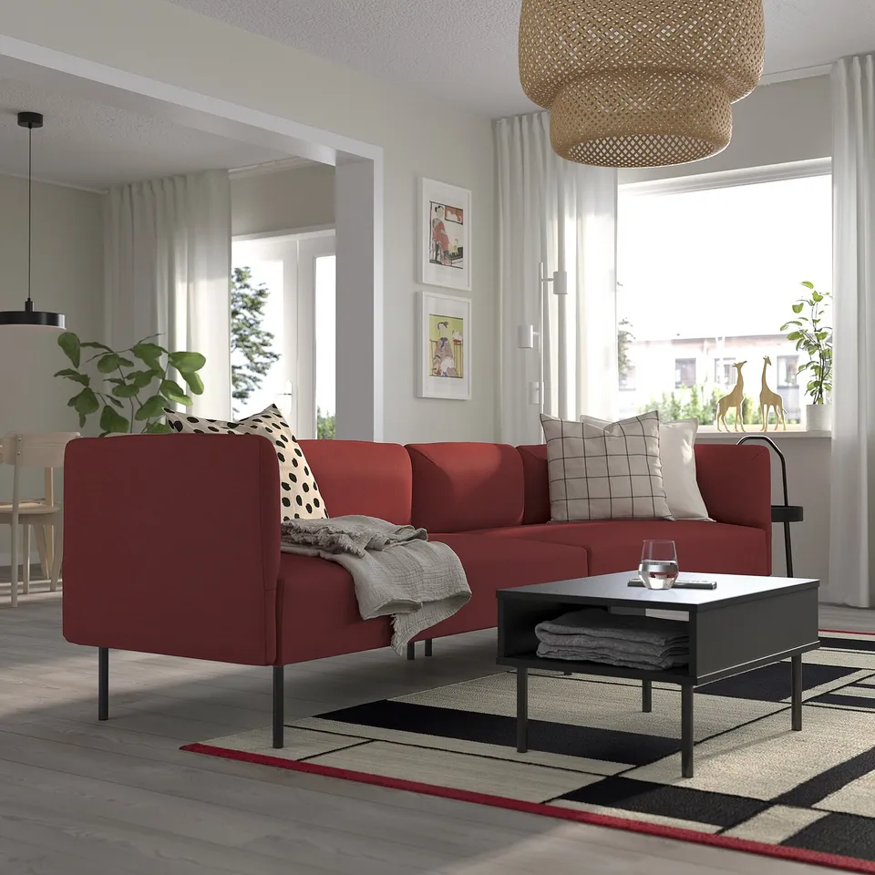 Bright red LILLEHEM modular sofa in living room, with grey pillows, black coffee table, and large window. Modern and cosy design.