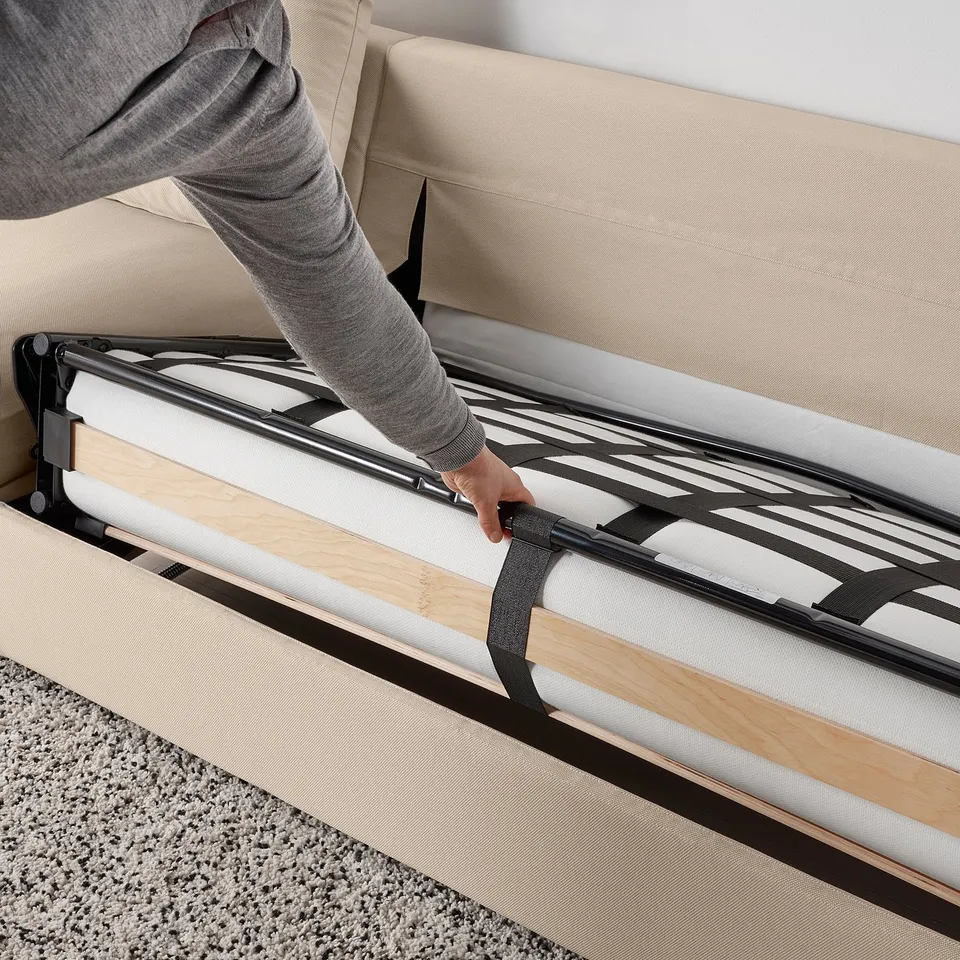 Person converting VIMLE sofa-bed into a bed, showing its easy transformation and thick mattress.