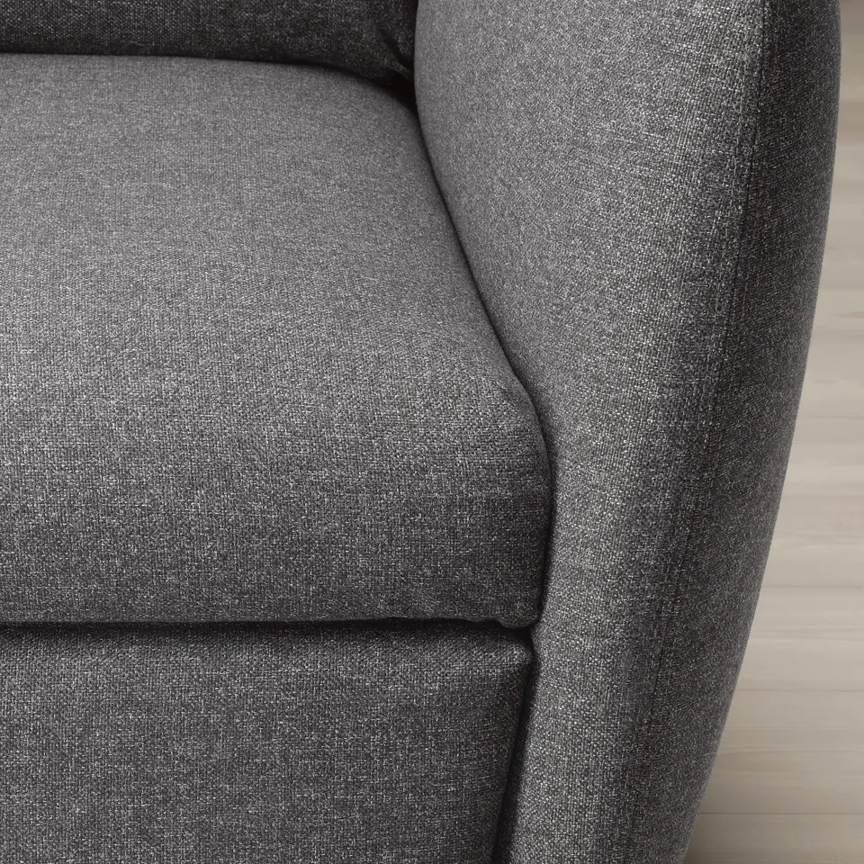 Close-up of a modern, dark grey fabric recliner. Soft, textured upholstery, comfortable and inviting.