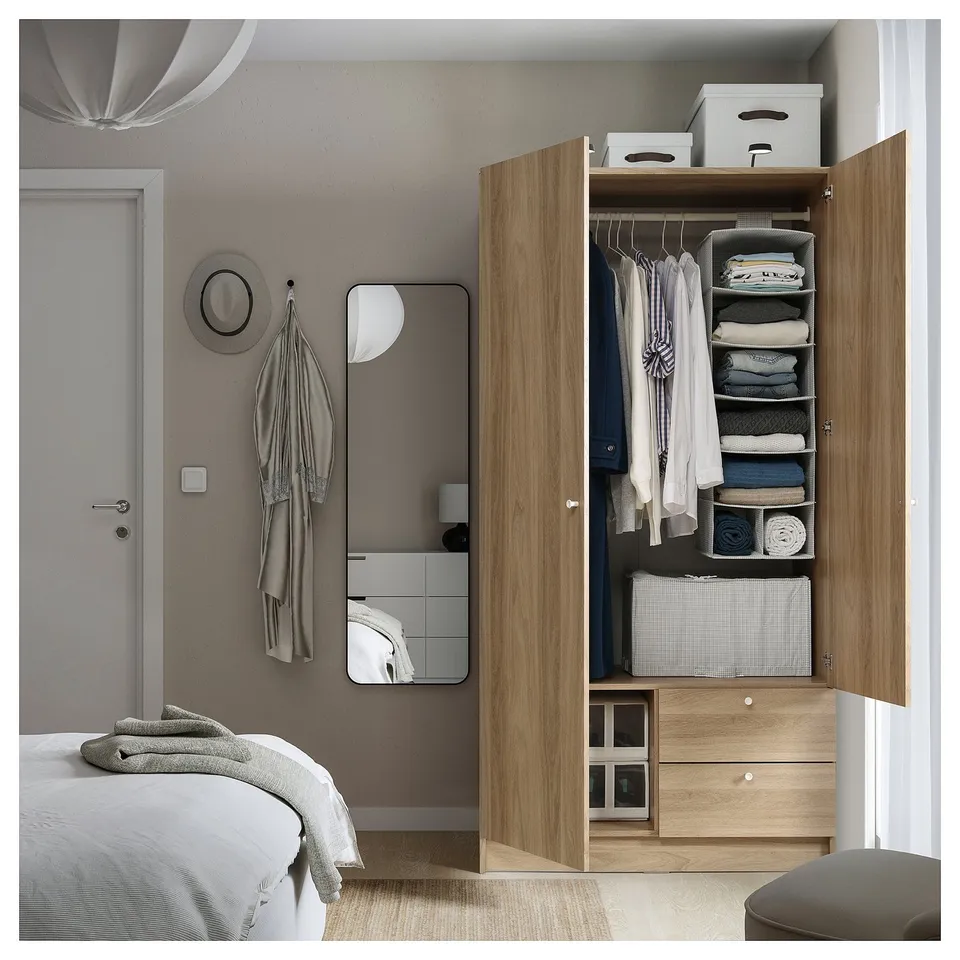 Modern bedroom with VILHATTEN oak wardrobe organisers, clothes hangers, storage boxes, and a grey mirror.