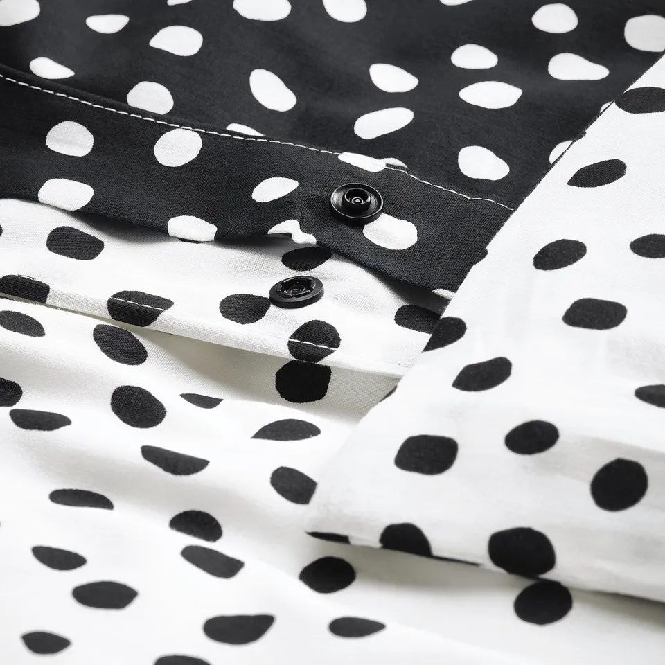 Black and white spotted duvet set with button closure. Soft, breathable fabric ensures comfort.