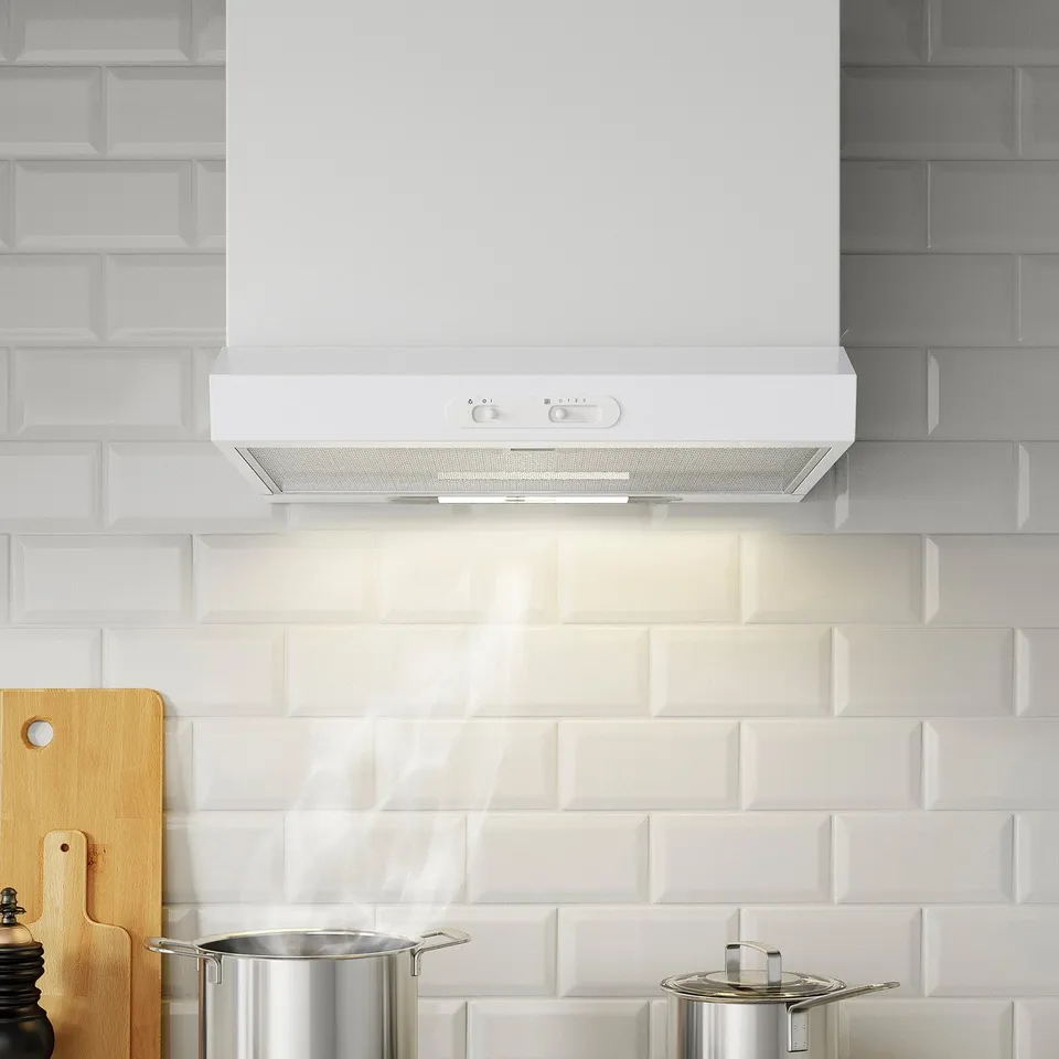 White kitchen hood with led lights and controls on front, mounted above tiles with metallic pots below.