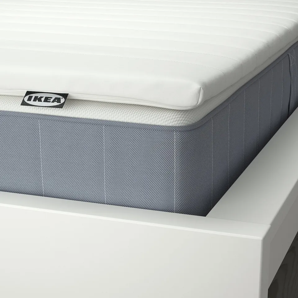 Close-up of a white IKEA mattress on a bed, showing its well-crafted stitching and supportive design.