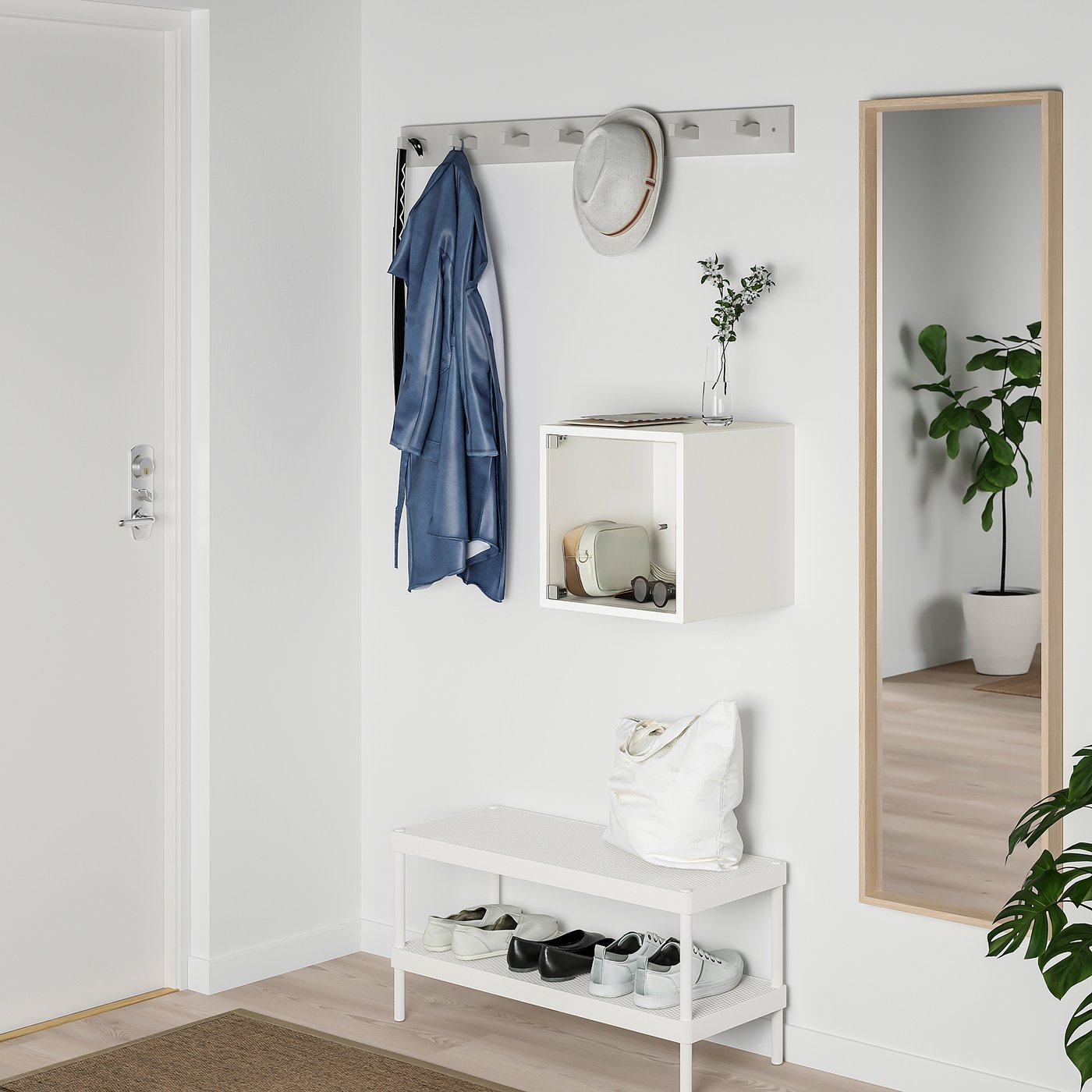 Wall-mounted EKET storage with bags and coat, mirror, plants.
