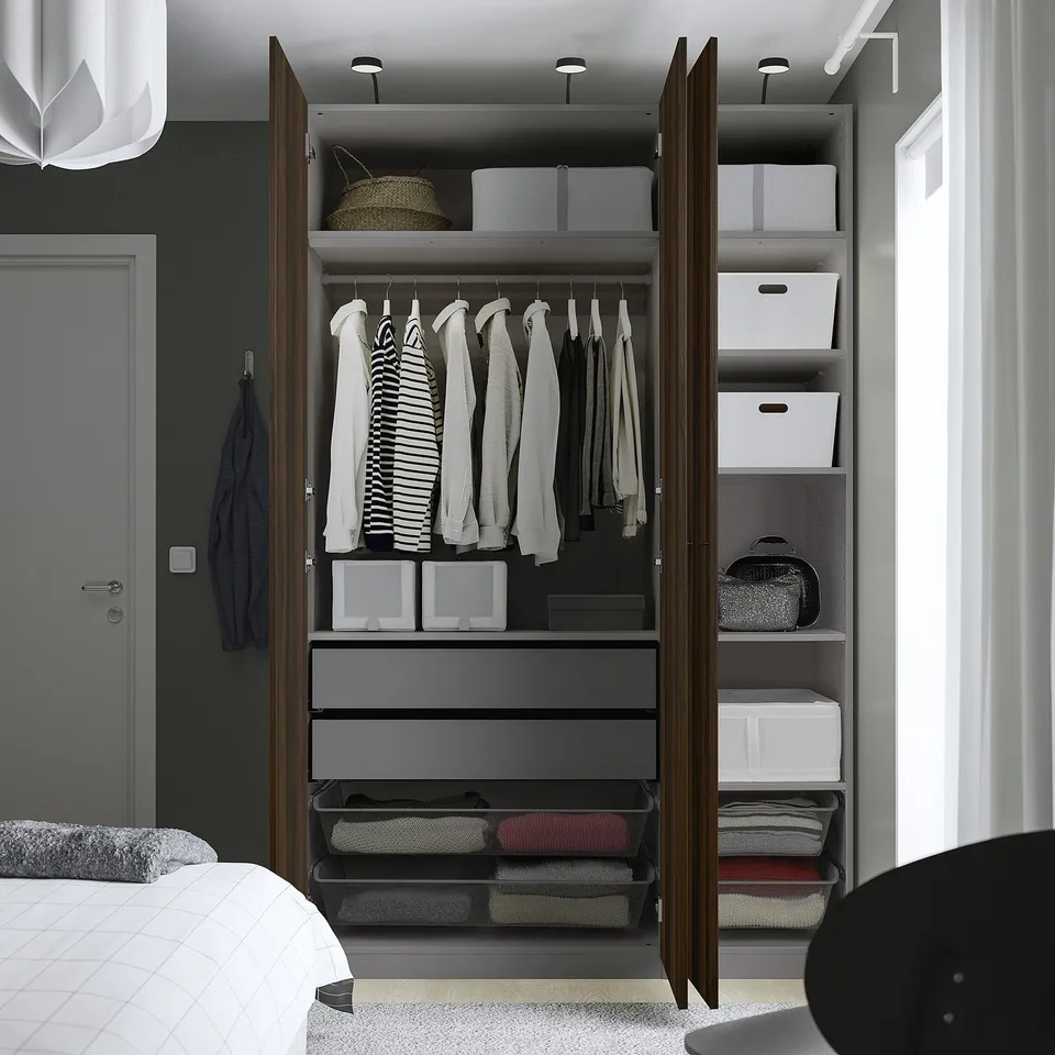 Open wardrobe displaying shirts, folded clothes, and storage boxes. Shelves and drawers organised for optimal space usage.