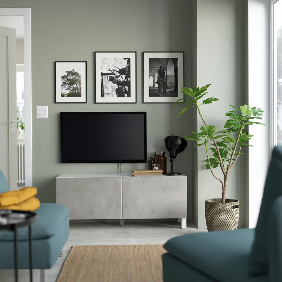 Modern living room with BESTÅ tv unit, art, plant, and turquoise furniture.