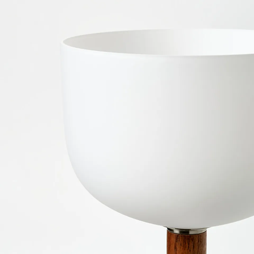 A modern floor lamp with a large opal glass shade, supported by a robust oak stem, reflecting quality craftsmanship and timeless design.