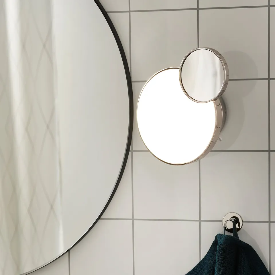Modern bathroom wall lamp with detachable magnifying mirror and adjustable led light, designed for versatile lighting and grooming tasks.