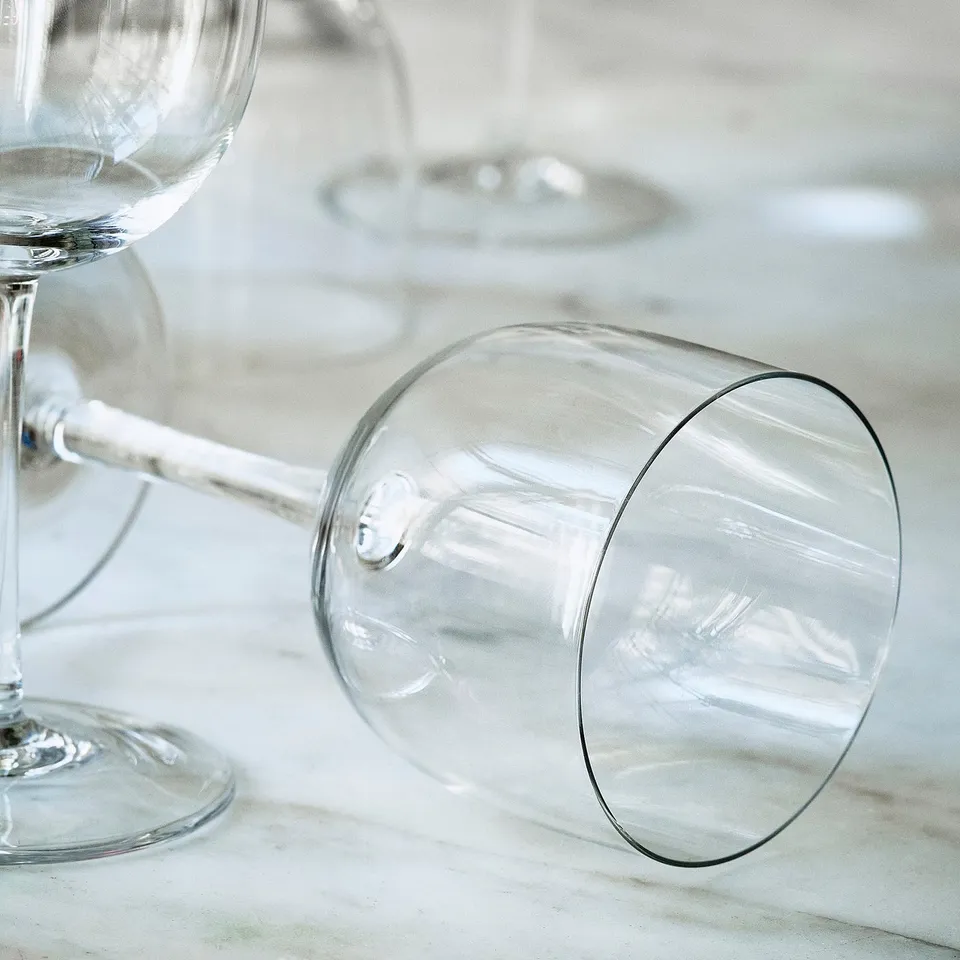 Elegant, thin, mouth-blown wine glass on sleek table, showcasing superior craftsmanship.