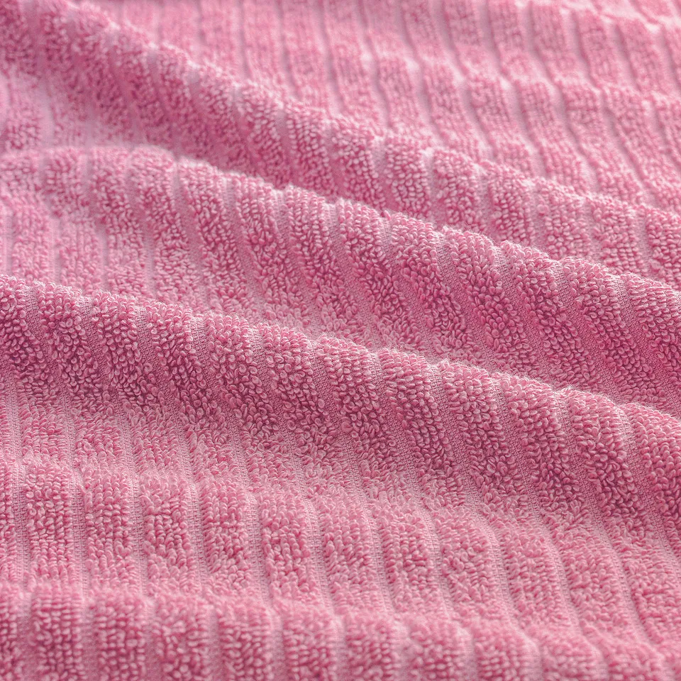 Close-up of soft pink terrycloth towel, showcasing its textured, absorbent surface and quality craftsmanship.