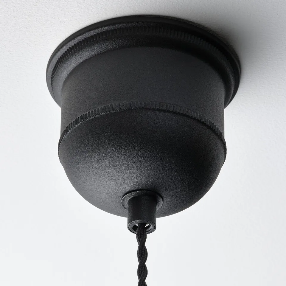 Black pendant lamp with woven design hangs from ceiling, showcasing high-quality craftsmanship and modern style.