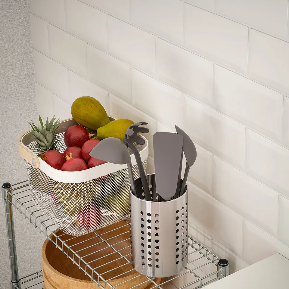Metal kitchen storage rack with visible fruit basket on top and utensil holder in front.