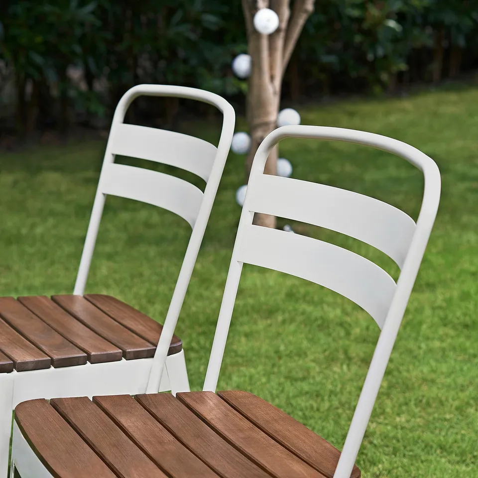 Two stackable NORRMANSÖ chairs outside, wooden seats, curved back.
