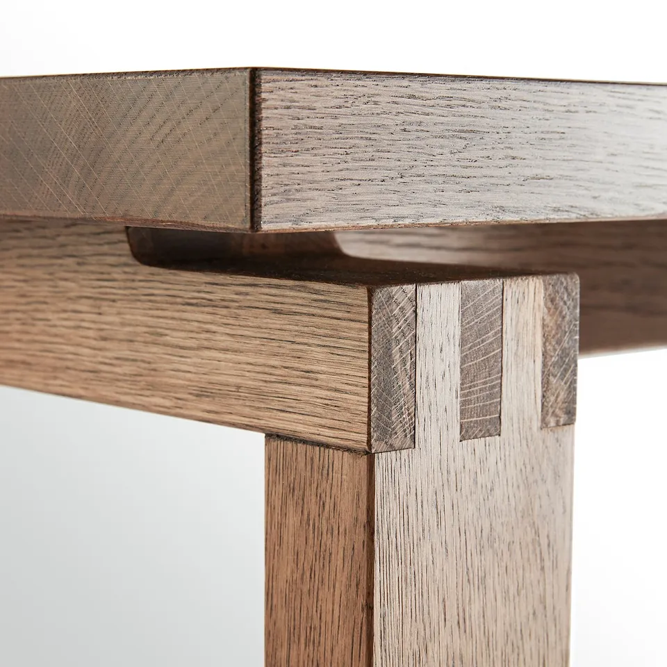 Wooden table corner detail, showing oak veneer and craftsmanship.