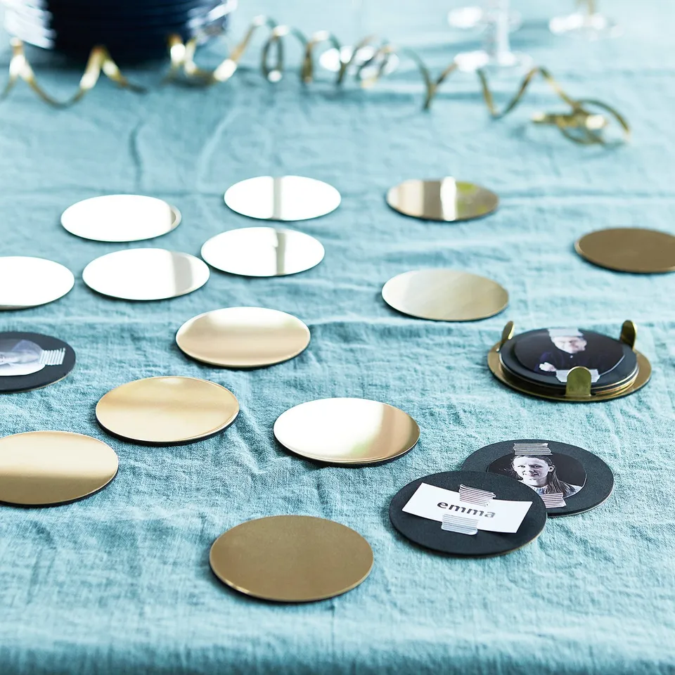 Gold coasters on blue table with name tag.