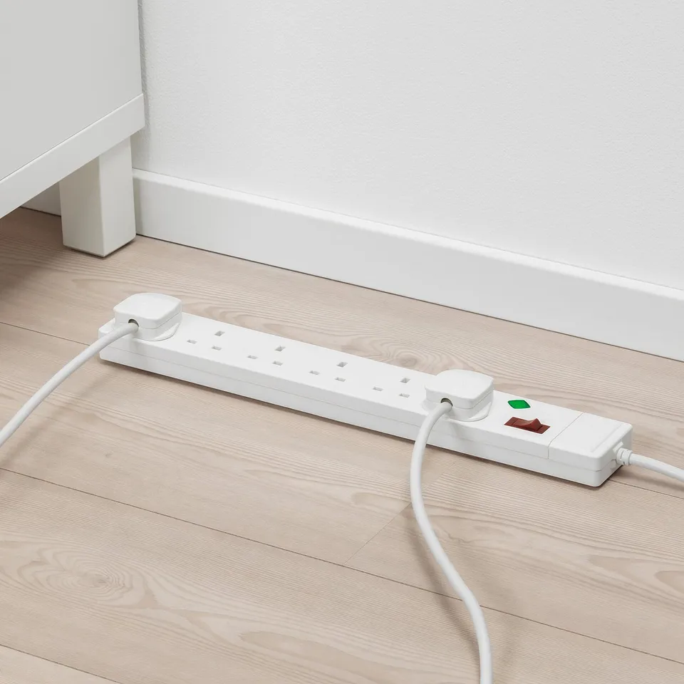White surge protector on wood floor, energy-saving.
