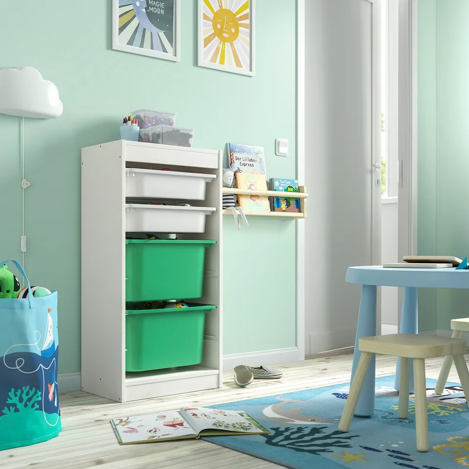 TROFAST toy storage with green/white bins in kids' room. Tall, kid-friendly design.
