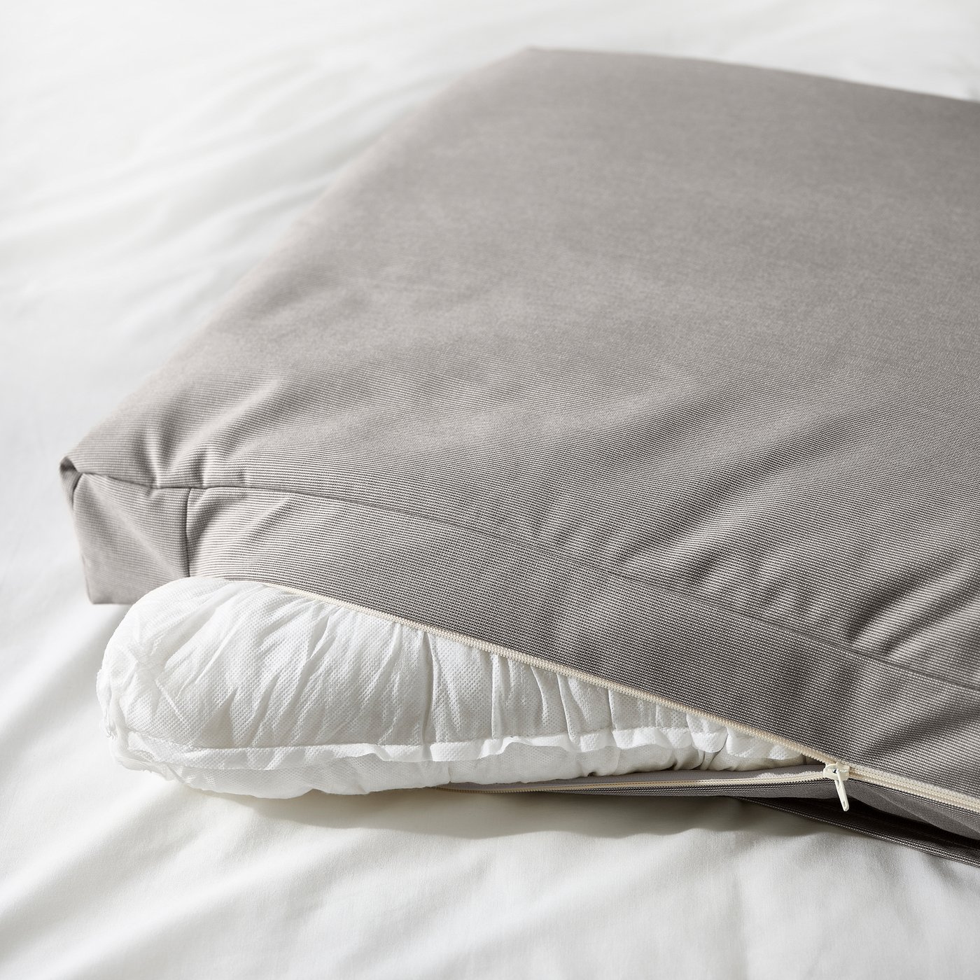 Upholstered bed with two soft pillows, removable cover, sloped headboard for reading or relaxing.
