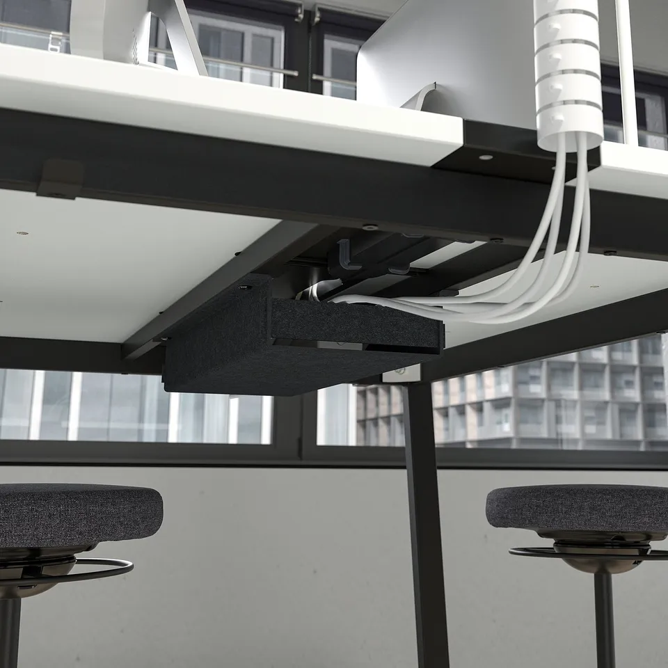 Office workstation with mounted computer screens and cables organised under sleek, black frames.