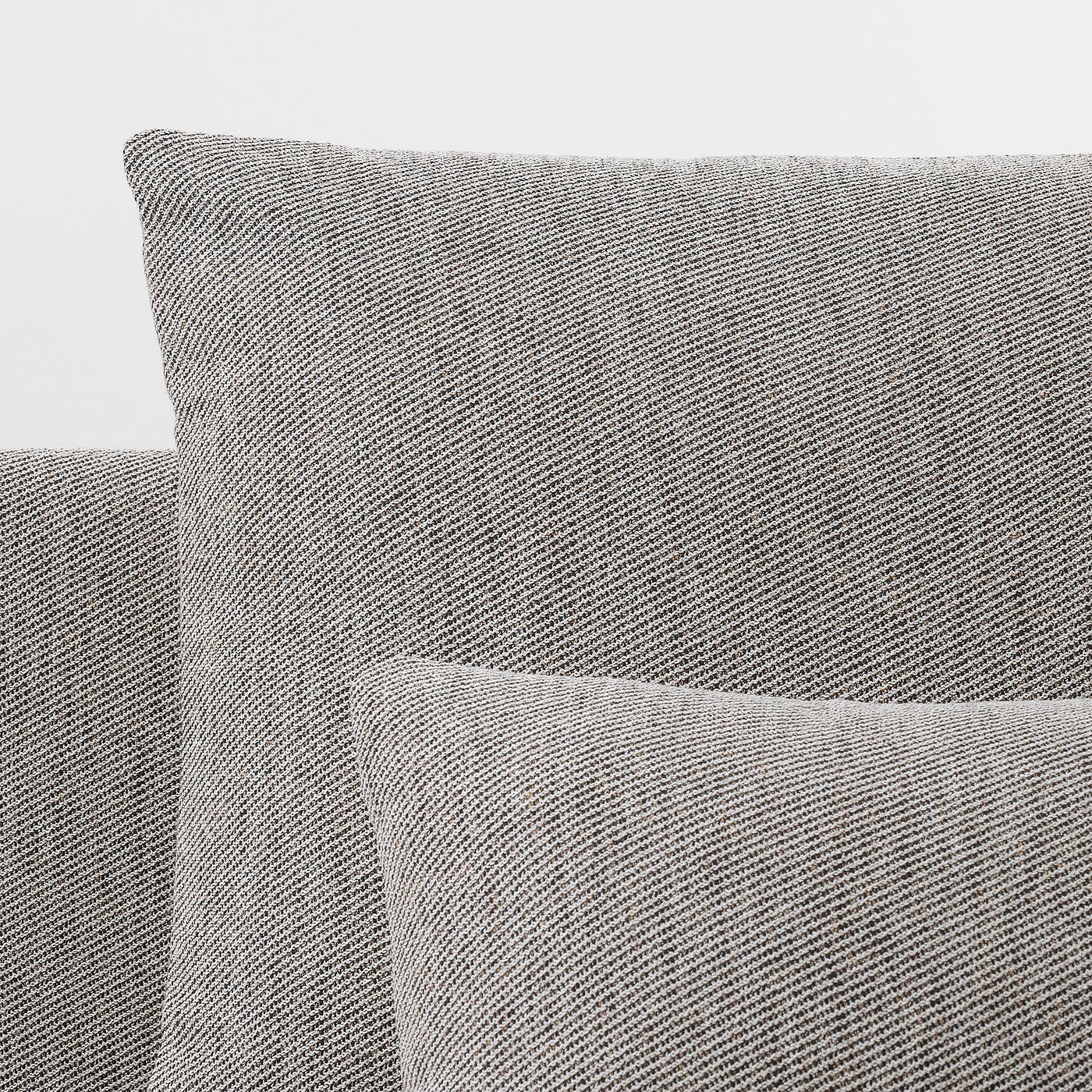 Close-up of a modern, upholstered sofa with clean lines, soft cushions, and a textured fabric in a neutral tone.