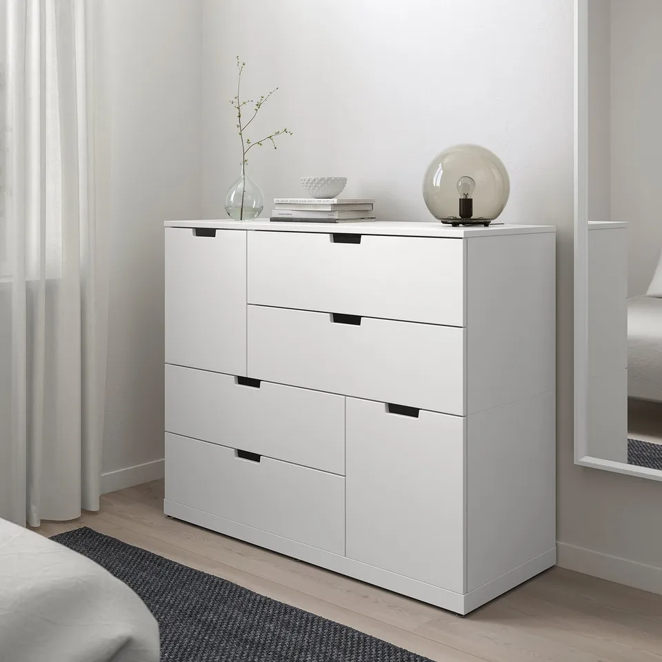 White NORDLI 6-drawer chest in modern bedroom beside window.