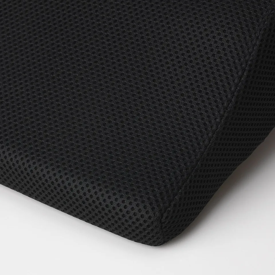 Black mesh lumbar cushion with small perforated pattern and sewn detailing, shown at an angle.