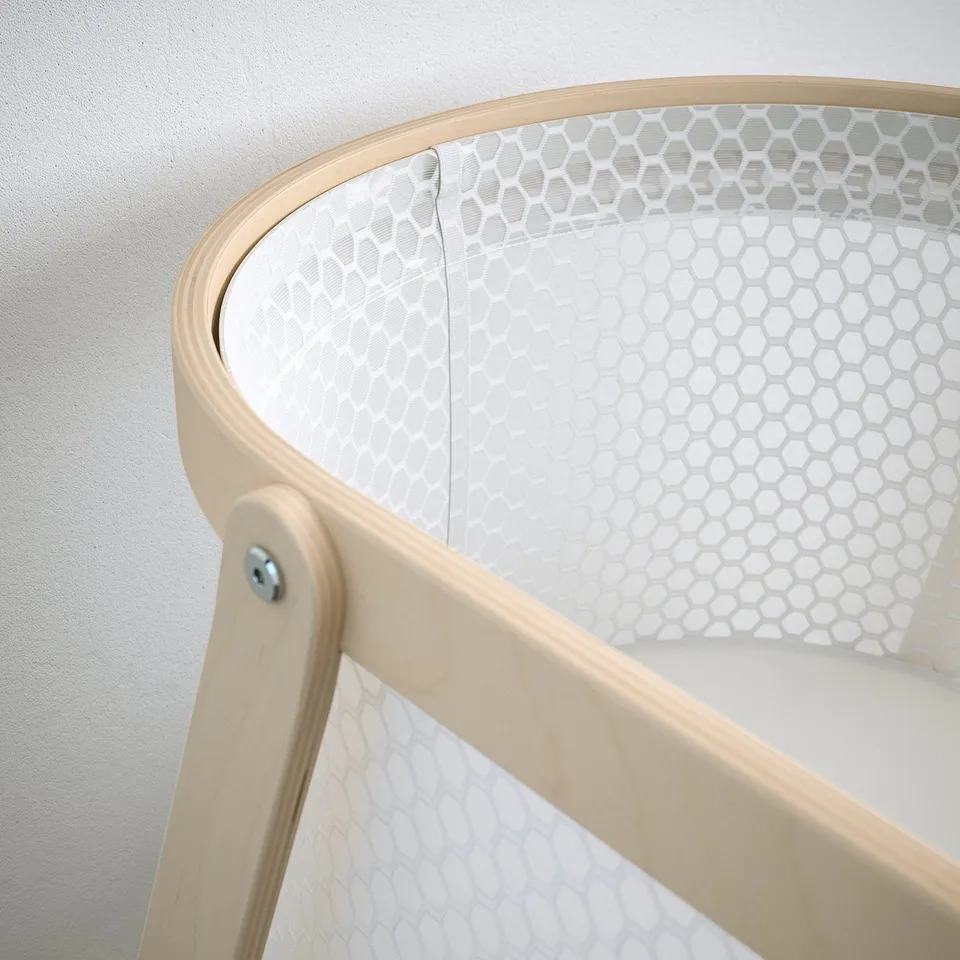 Modern bassinet with sleek wooden frame and breathable mesh side, perfect for babys comfort and visibility.